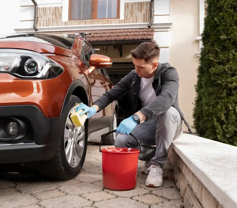 Lavage auto à domicile Sainte-Scolasse-sur-Sarthe : professionnel intervenant sur un véhicule